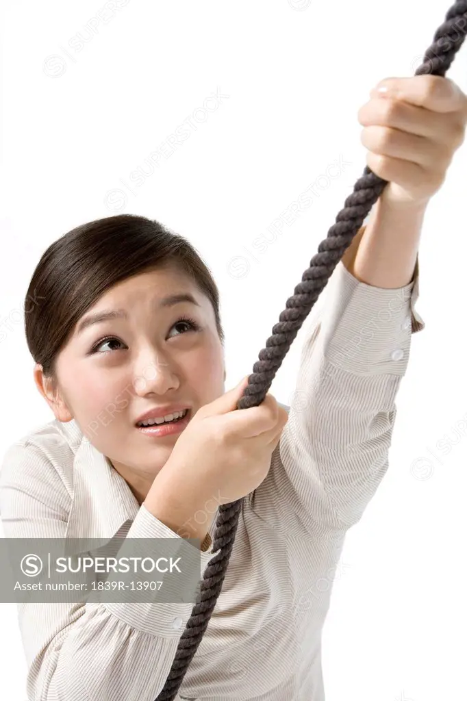Businesswoman climbing rope
