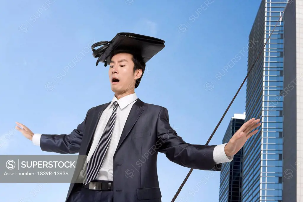 Businessman walking on rope in mid_air