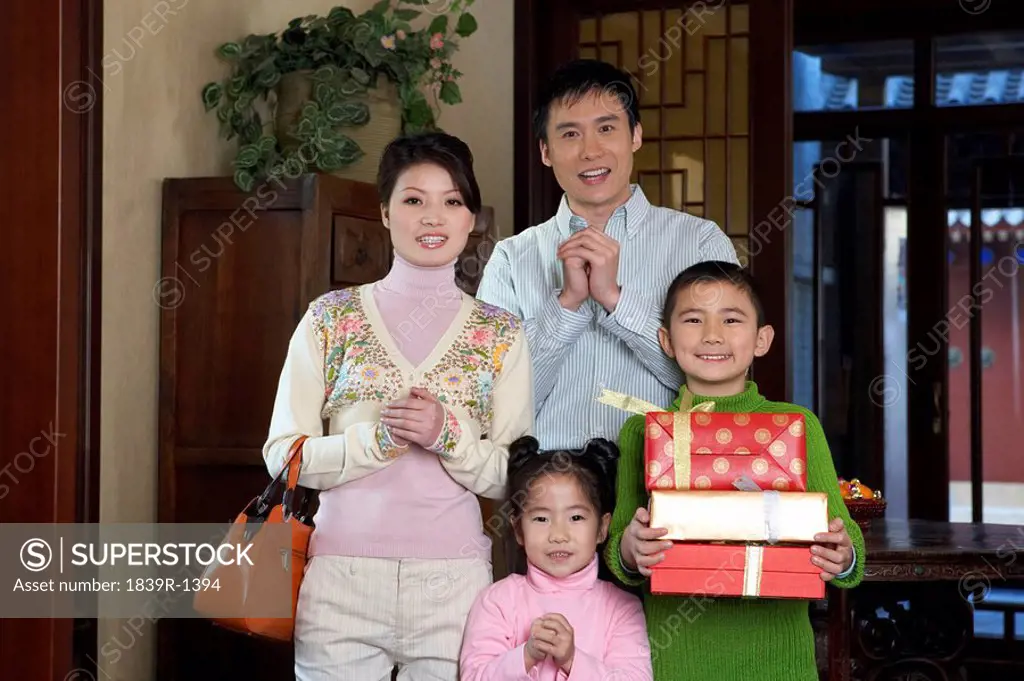 Family Standing Together Holding Gifts