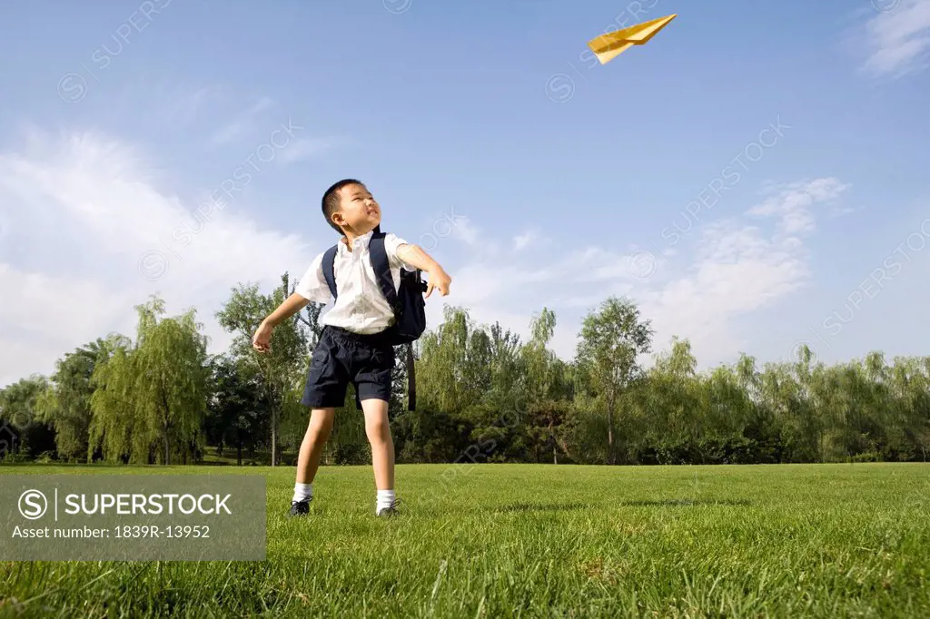 Boy playing with a paper airplane