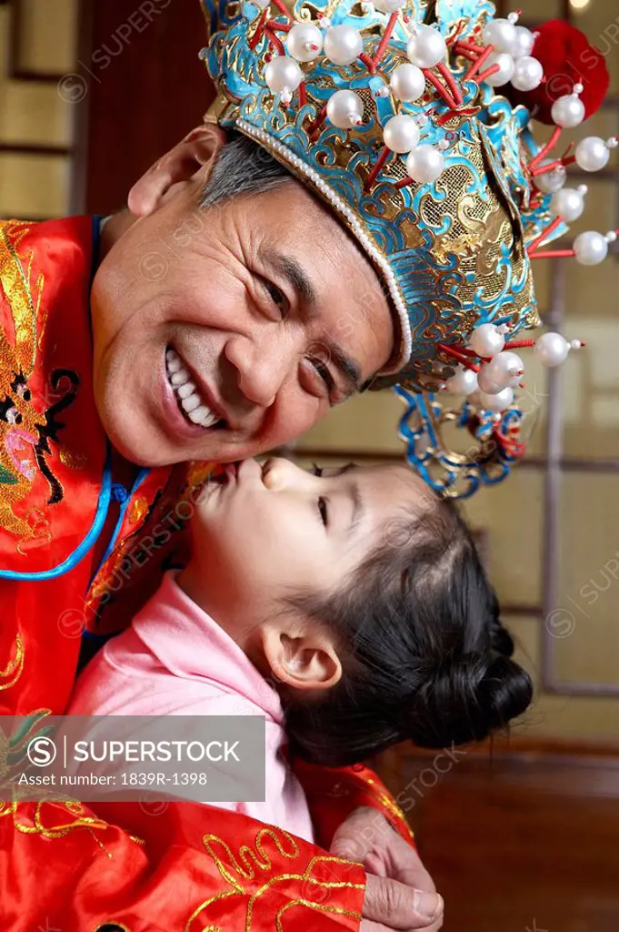 Granddaughter Kissing Her Traditionally Dressed Grandfather
