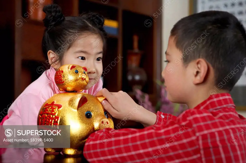 Children Playing With Gold Piggy Banks