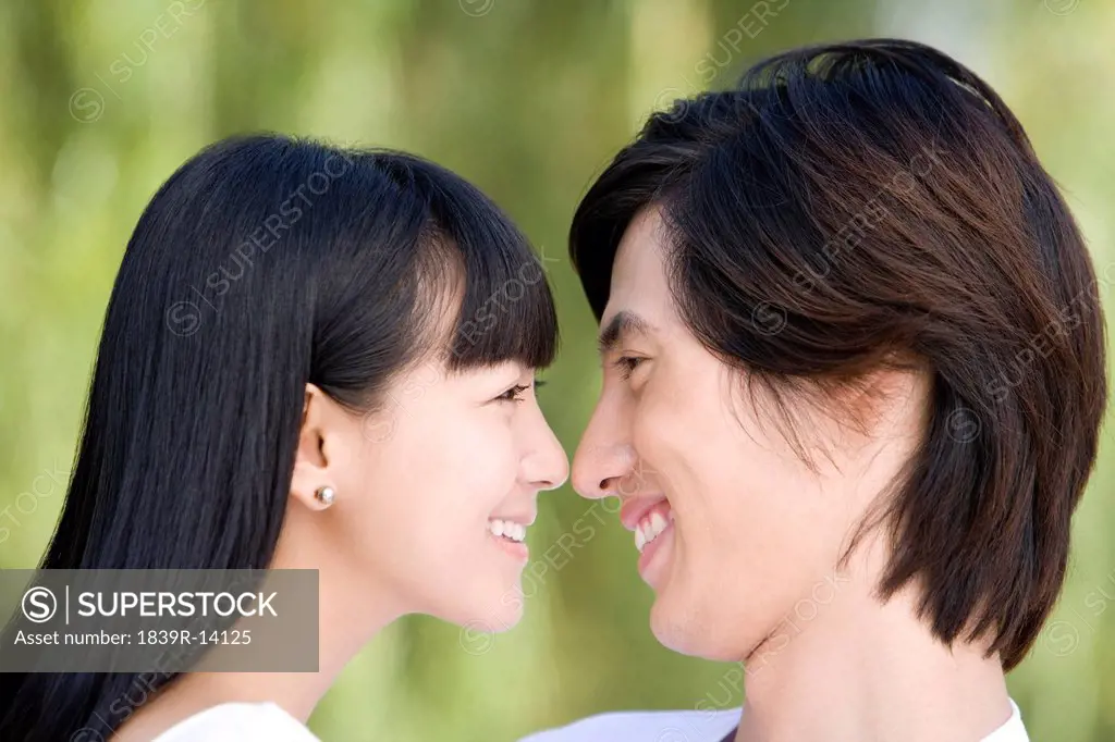 Close_up of young couple smiling to each other