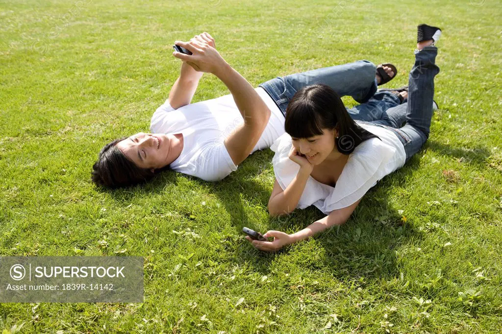 Young couple using cellphone outdoors