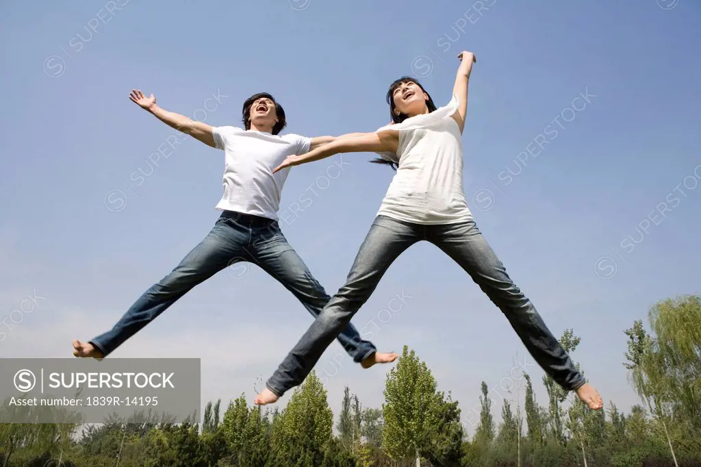 Young couple jumping in mid_air