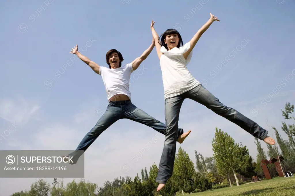 Young couple jumping in mid_air