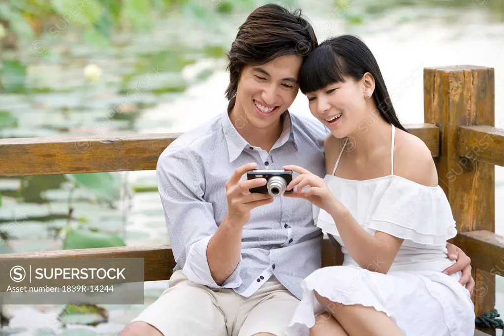 Young couple using digital camera outdoors