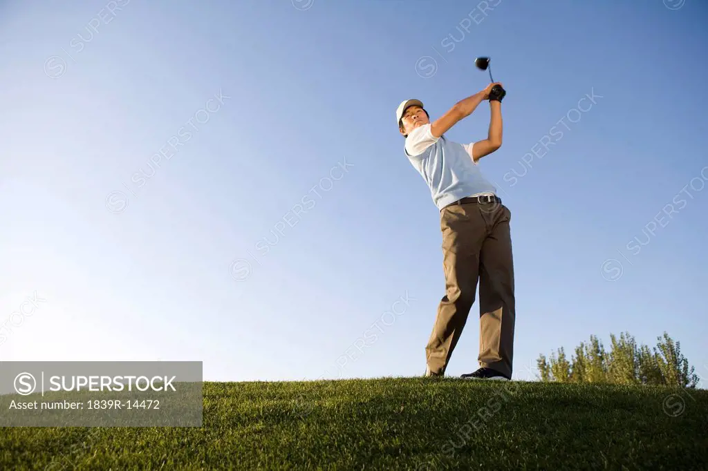 Golfer teeing off on the course