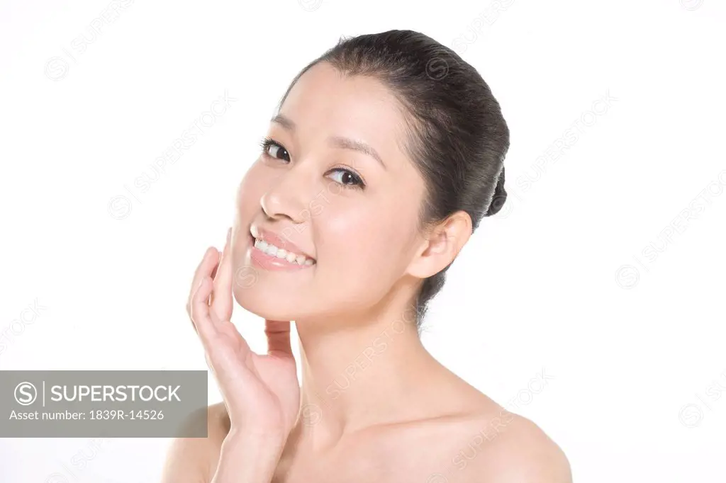 Beauty shot of a young woman touching her face