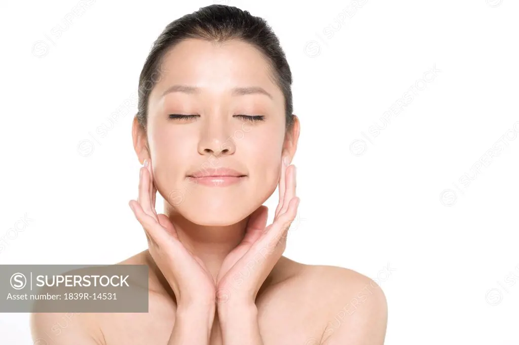 Beauty shot of a young woman touching her face