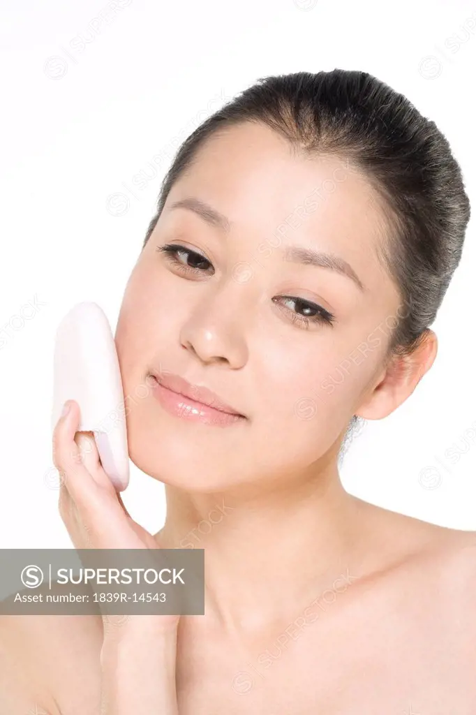 Young woman holding a powder puff