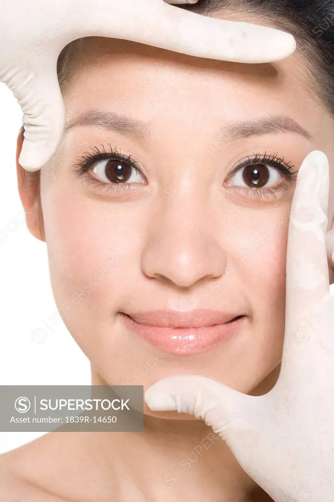 Surgical gloves framing a young woman´s face
