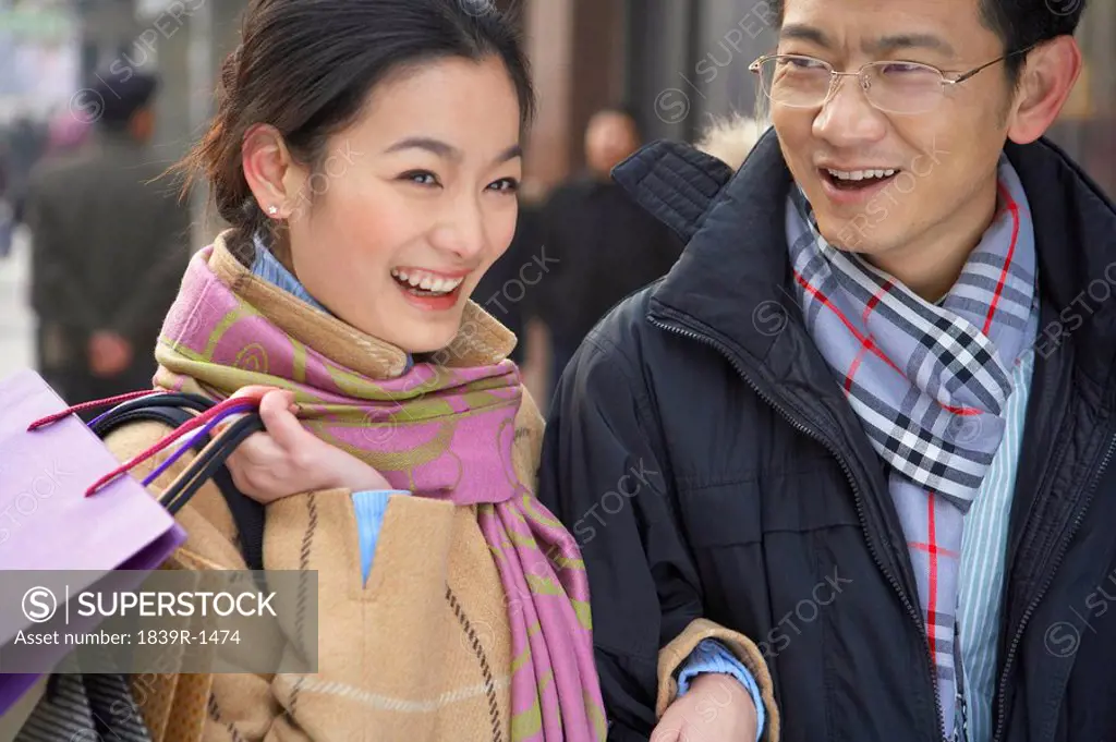 Young Couple Holding Shopping Bags, Laughing