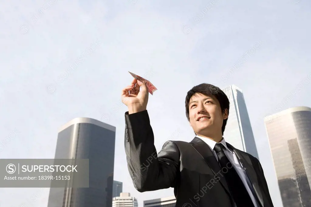 Businessman Flying RMB Paper Airplane