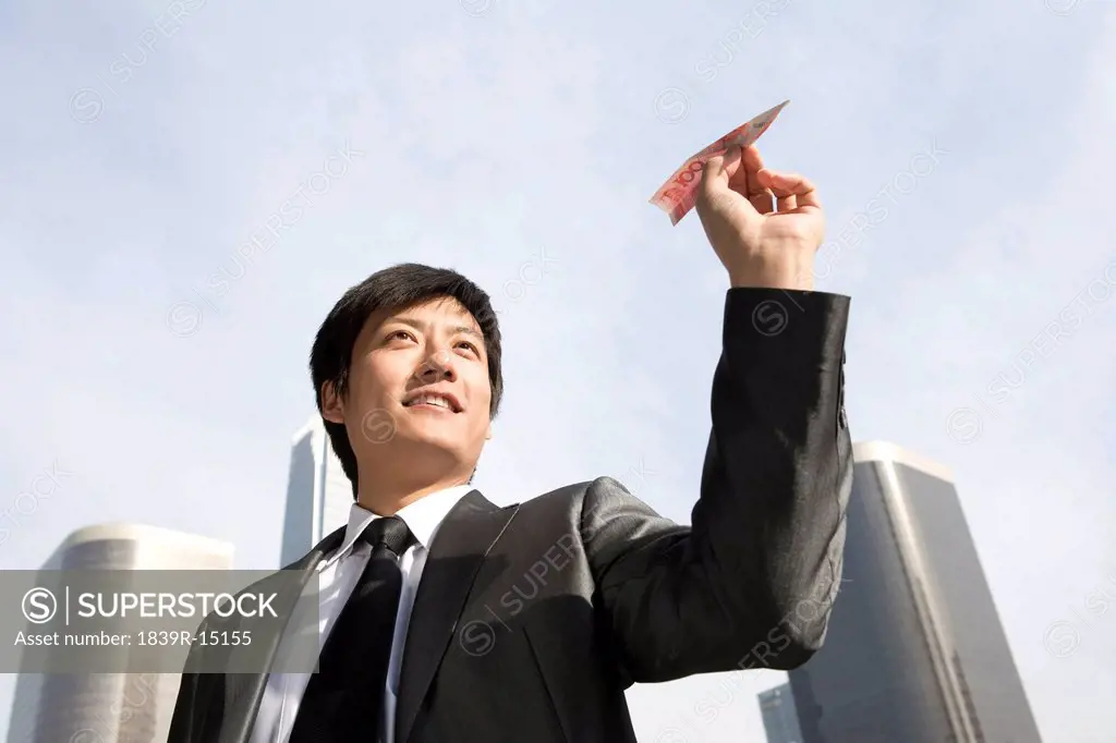 Businessman Flying RMB Paper Airplane