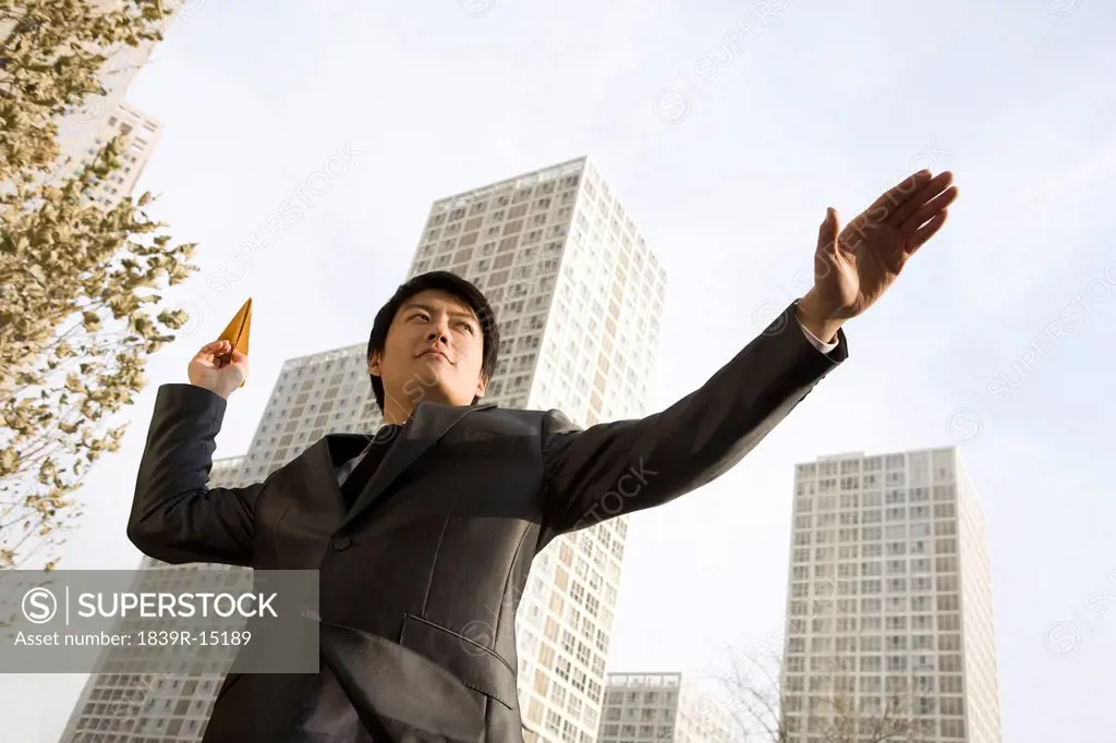 Businessman throwing paper airplane