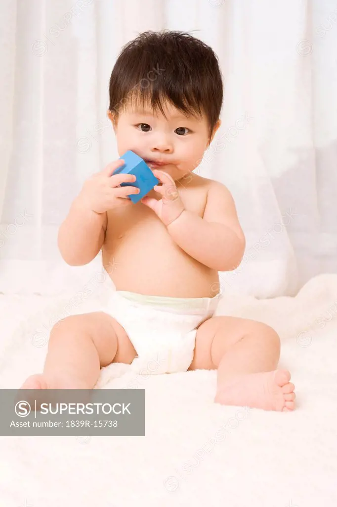 Baby holding a toy block