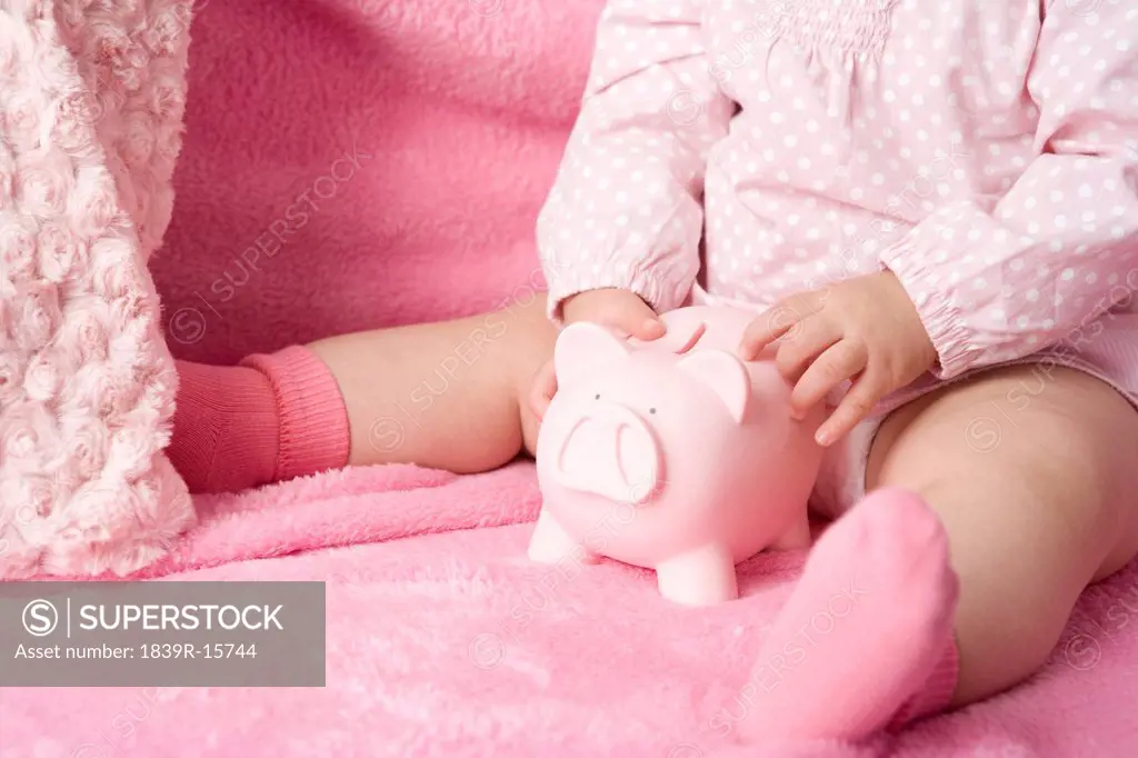 Baby putting money in the piggybank