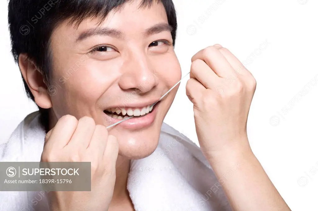 Young man using dental floss
