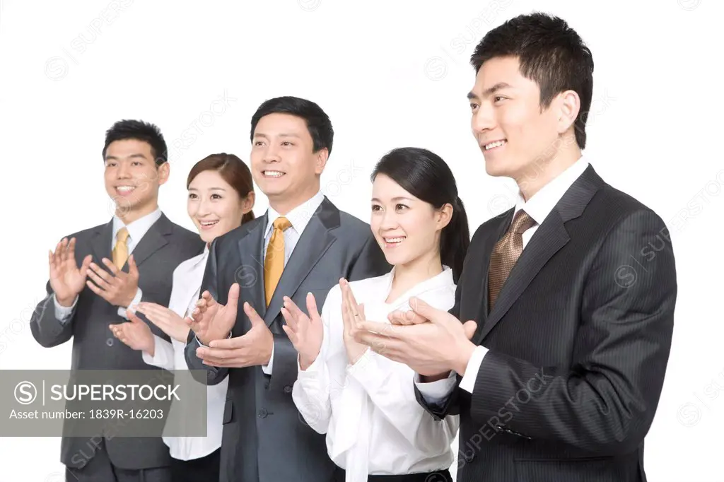 Business people in a row clapping