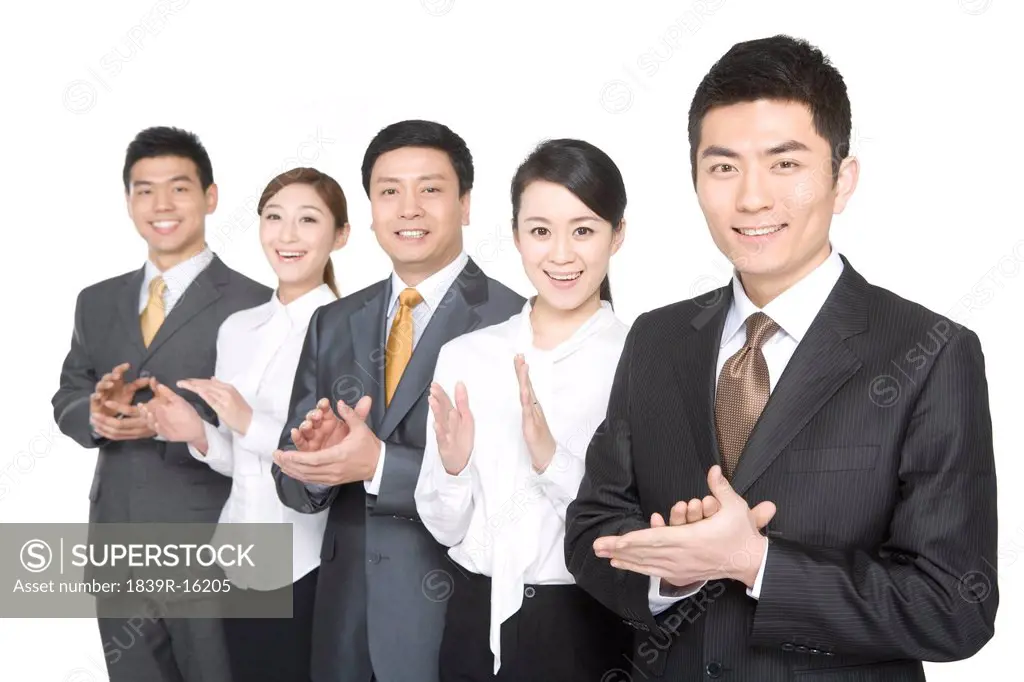 Business people in a row clapping