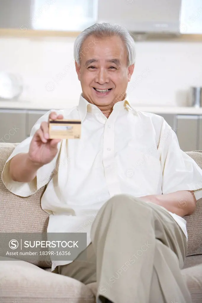 Portrait of a senior man holding a credit card