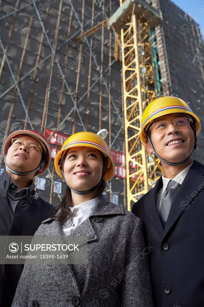 Businesspeople In Construction Site Wearing Hard Hats