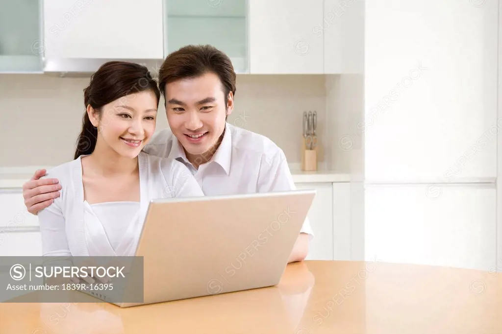 Young couple using a laptop at home