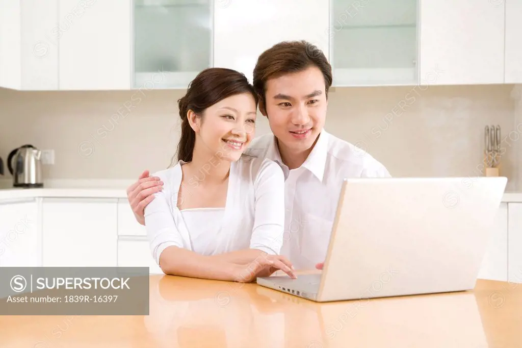 Young couple using a laptop at home