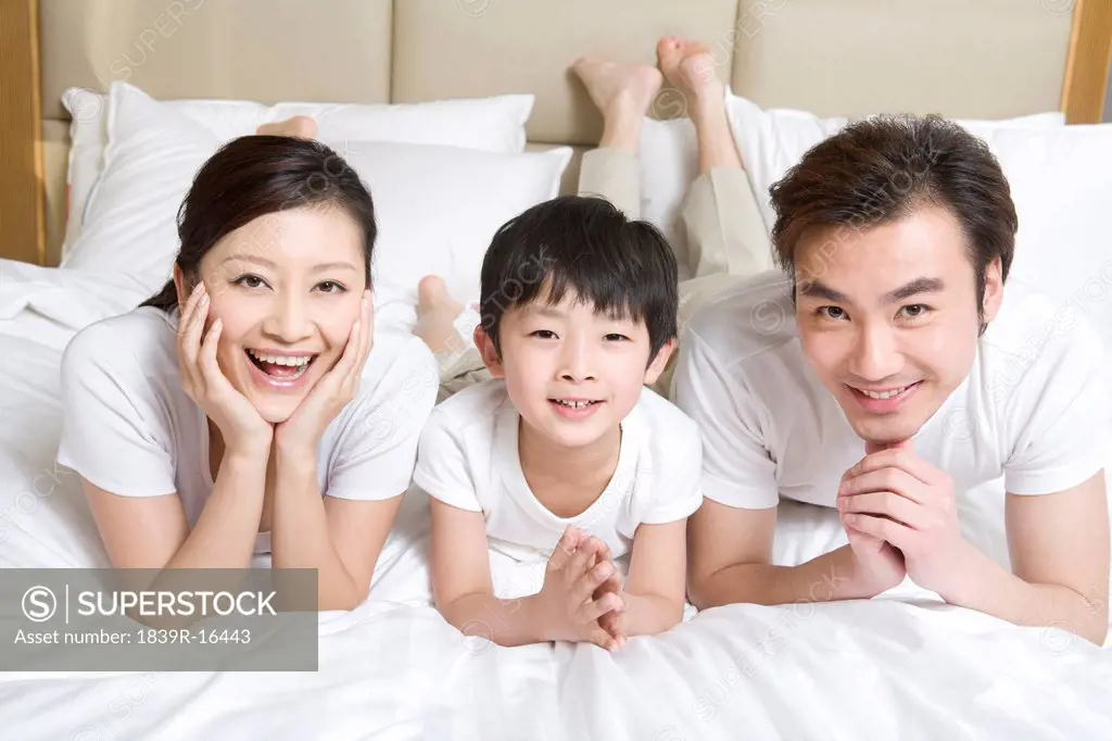 Portrait of a young family on a bed