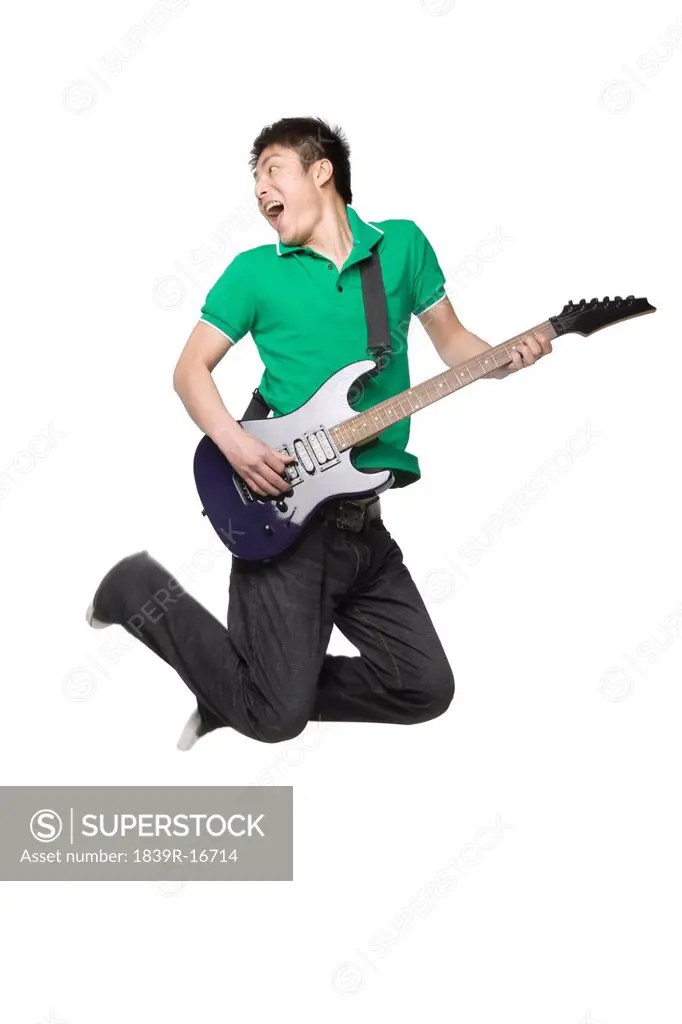 Young man playing an electric guitar