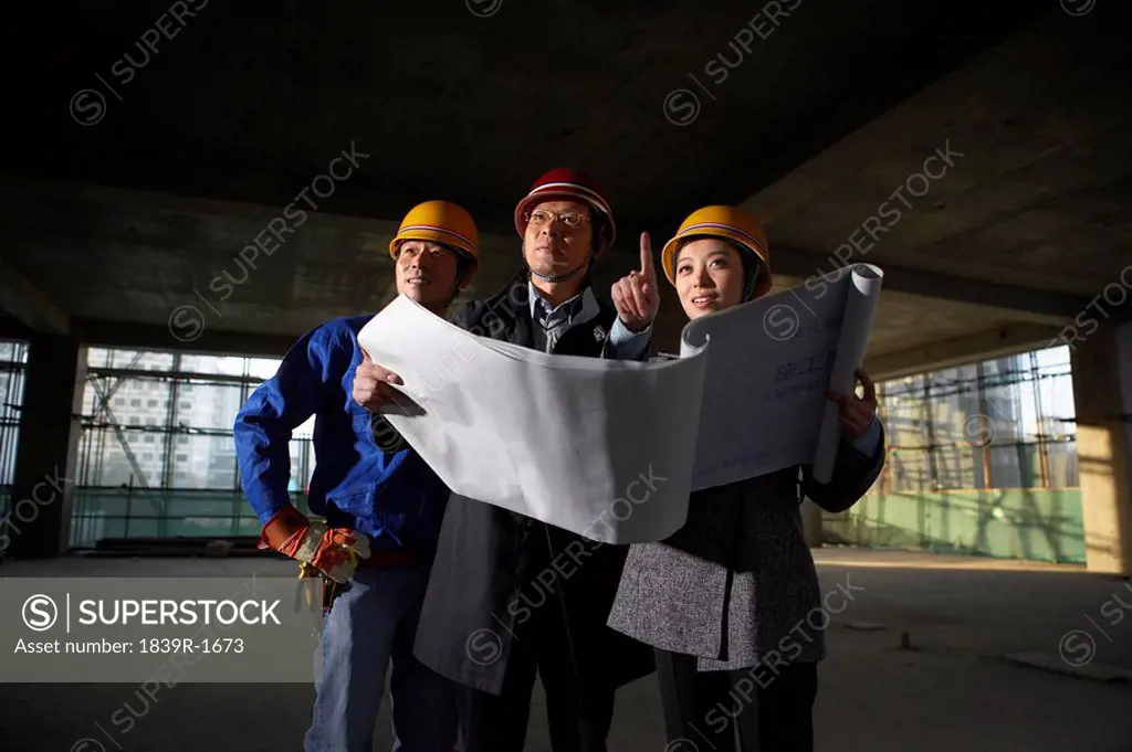 Businesspeople In Construction Site Wearing Hard Hats