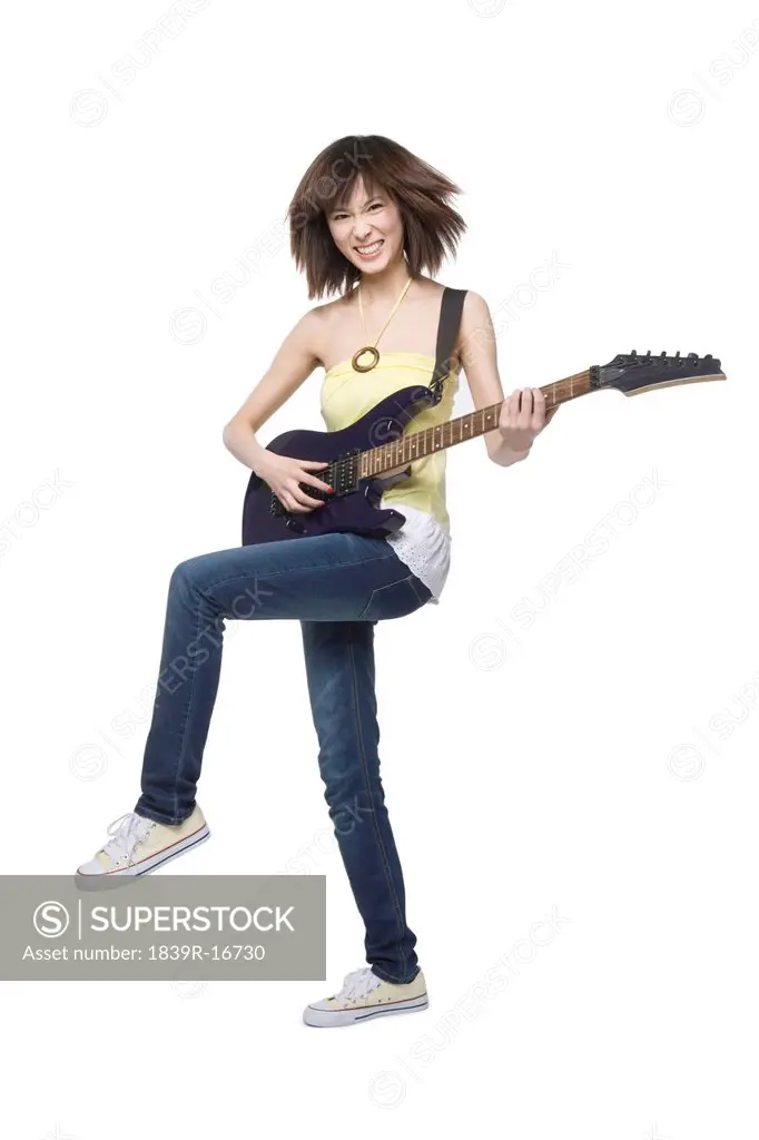 Young woman playing an electric guitar