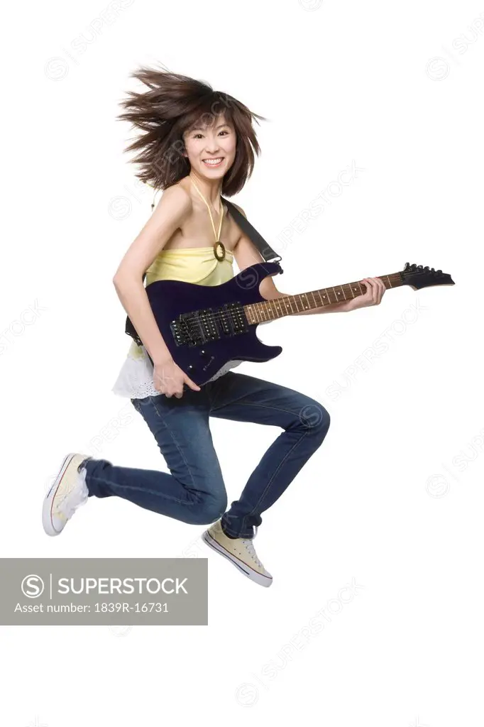 Young woman playing an electric guitar