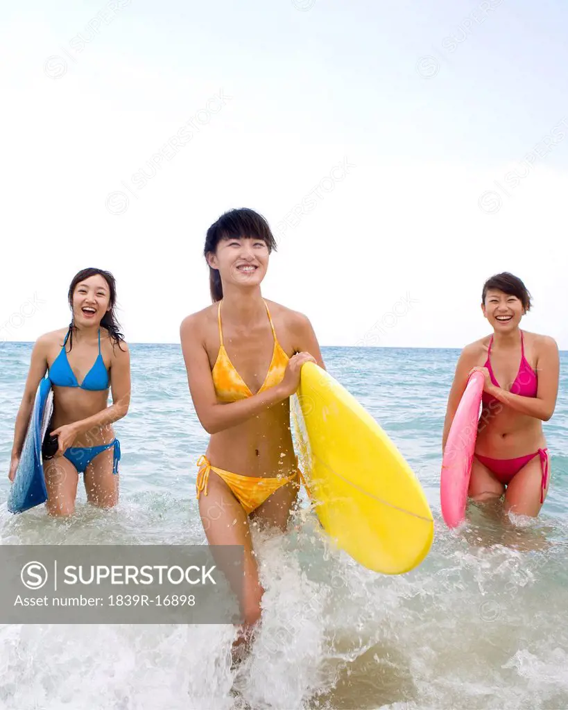 Three girls with surfboards