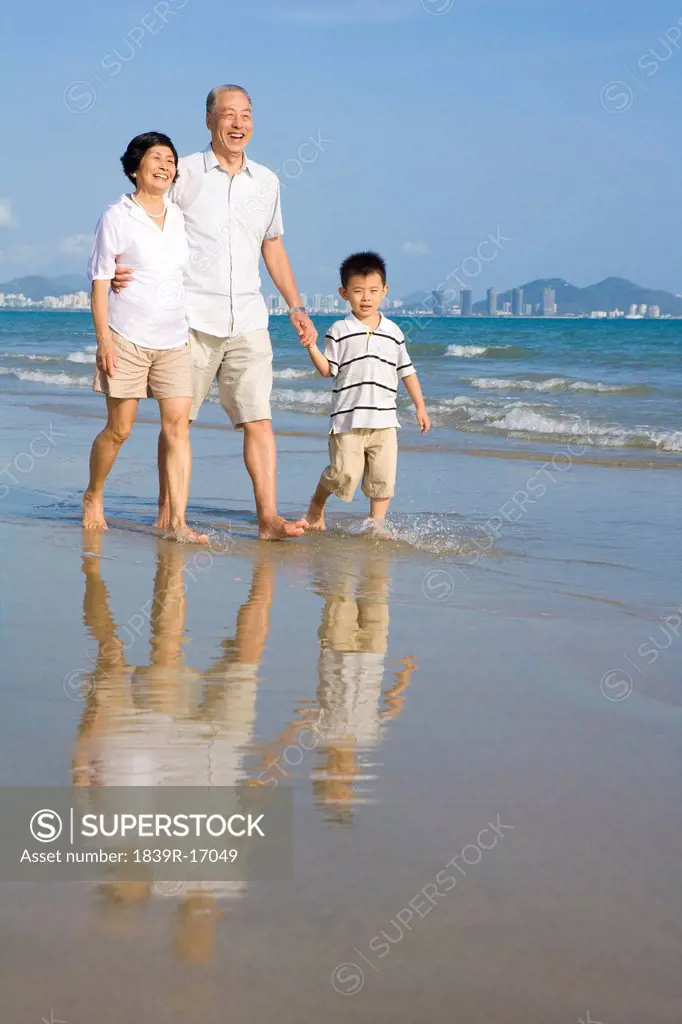 Grandparents and grandson walking along the beach