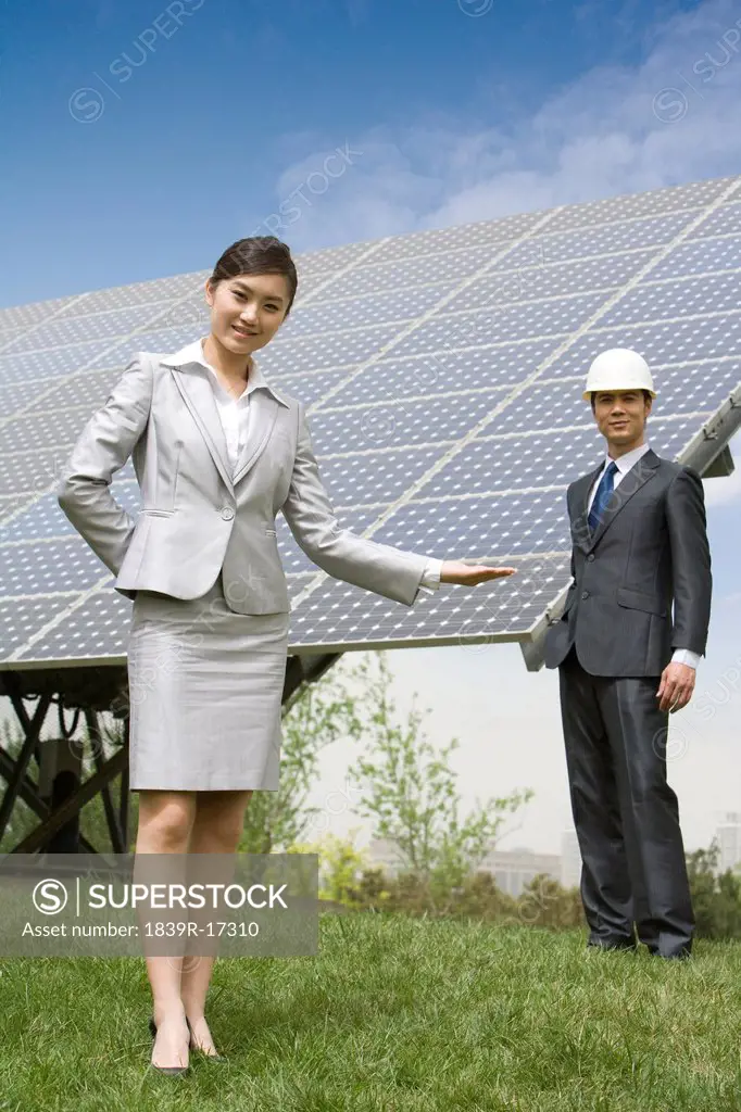 Two business associates in front of solar panels
