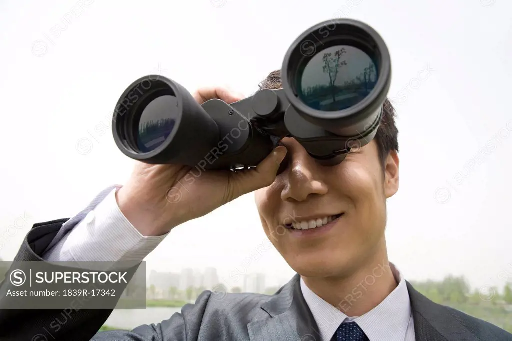 Businessman using binoculars
