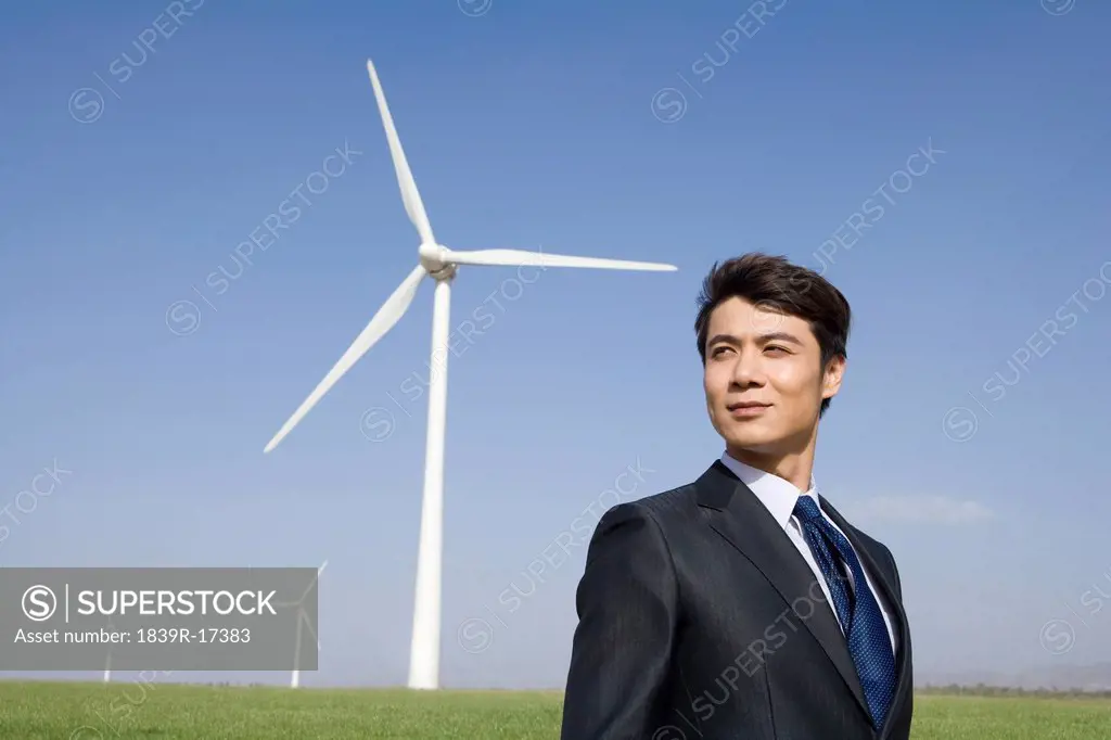 Businessman in front of wind turbine