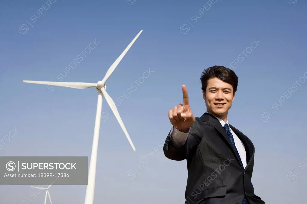 Businessman in front of wind turbine