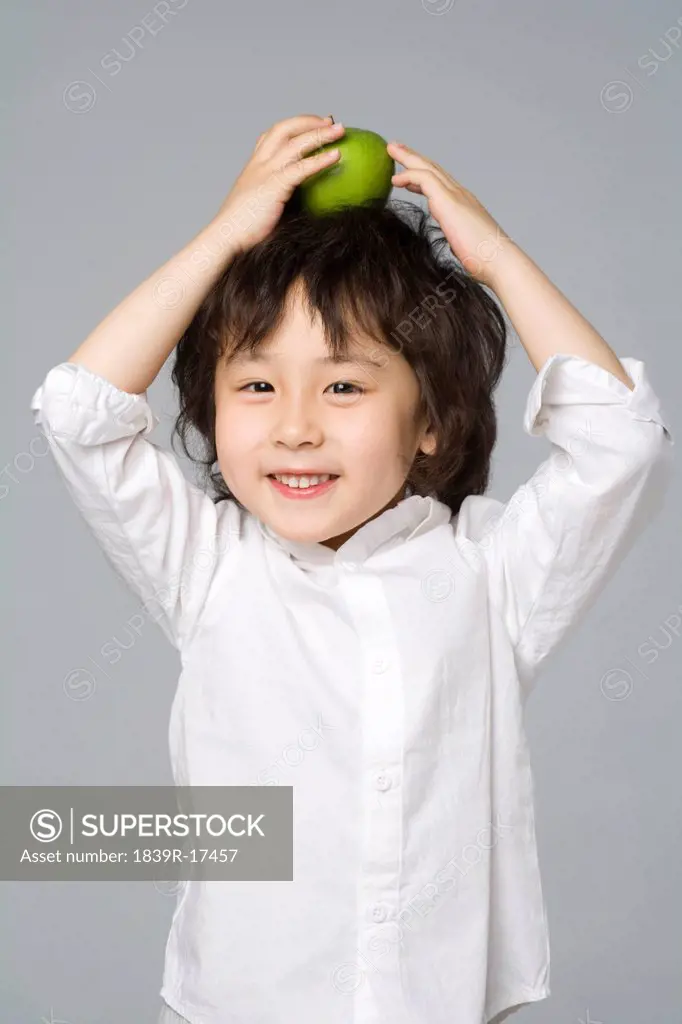 Boy balancing an apple on his head