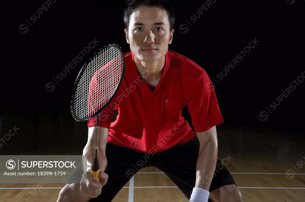 Young Man Preparing To Return A Shot During A Game Of Badminton