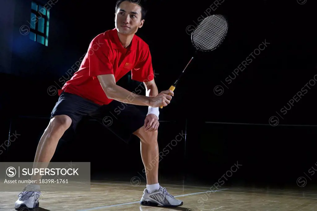 Young Man Preparing To Return A Shot During A Game Of Badminton