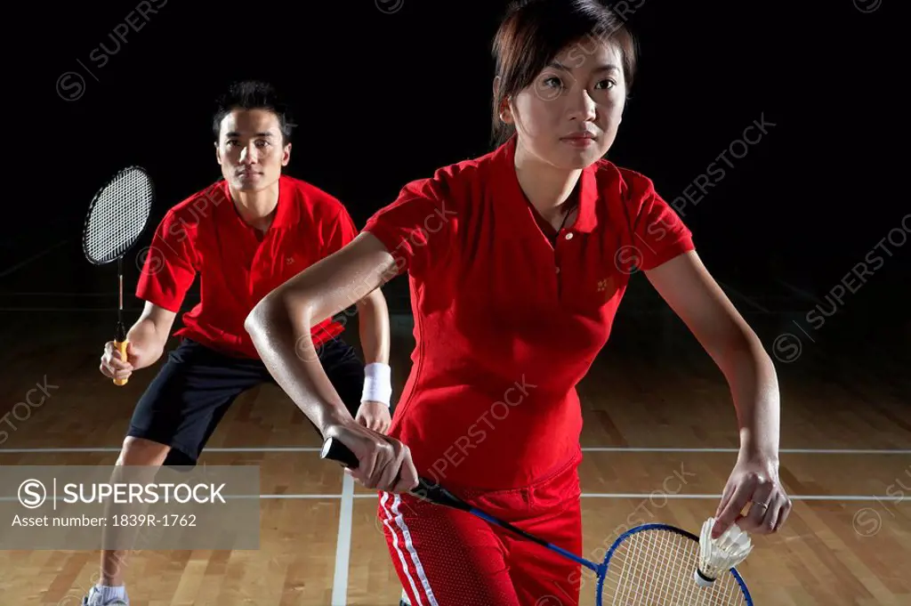 Young Man And Woman Preparing To Return A Badminton Shot