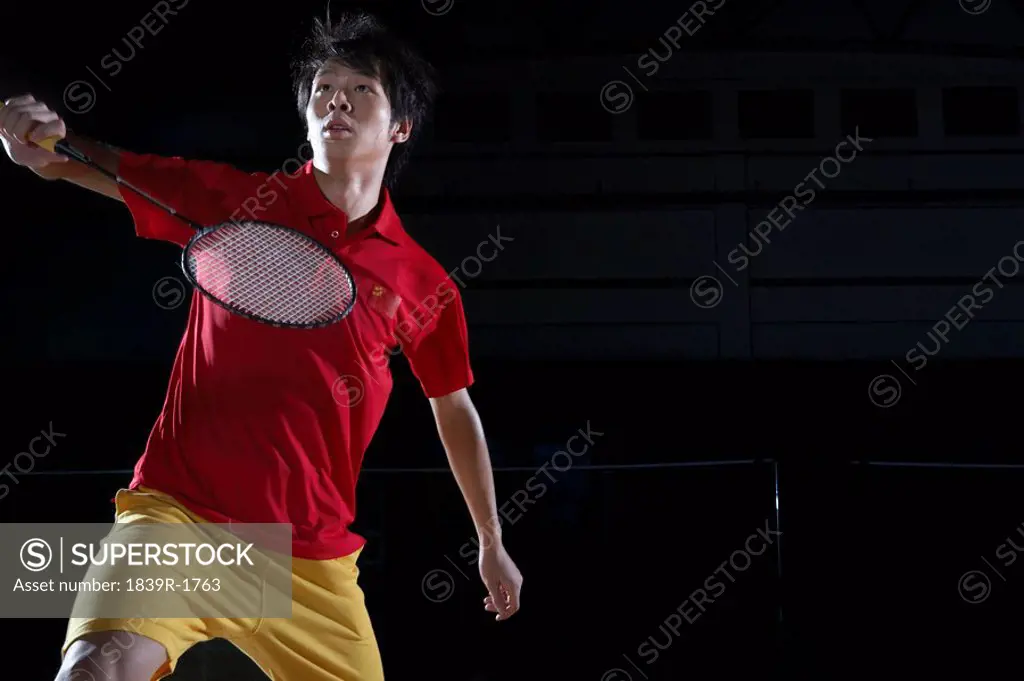 Young Man Prepares To Return A Shot During A Game Of Badminton