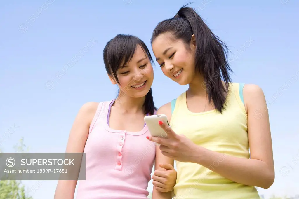 Two young women with a mobile phone