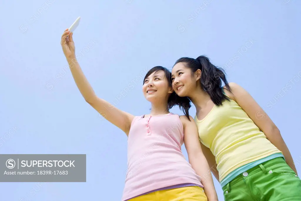 Two young women with a mobile phone