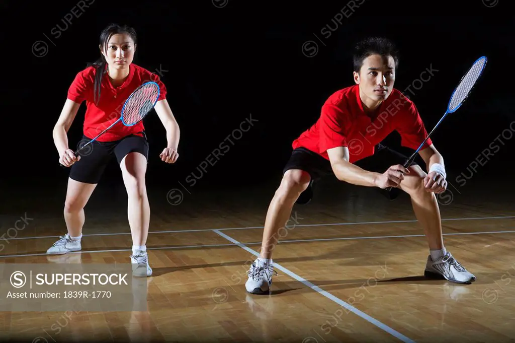 Man And Woman In Action Playing Badminton