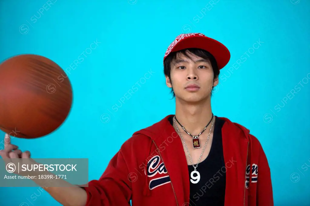 Young Man Spinning A Basketball On His Finger