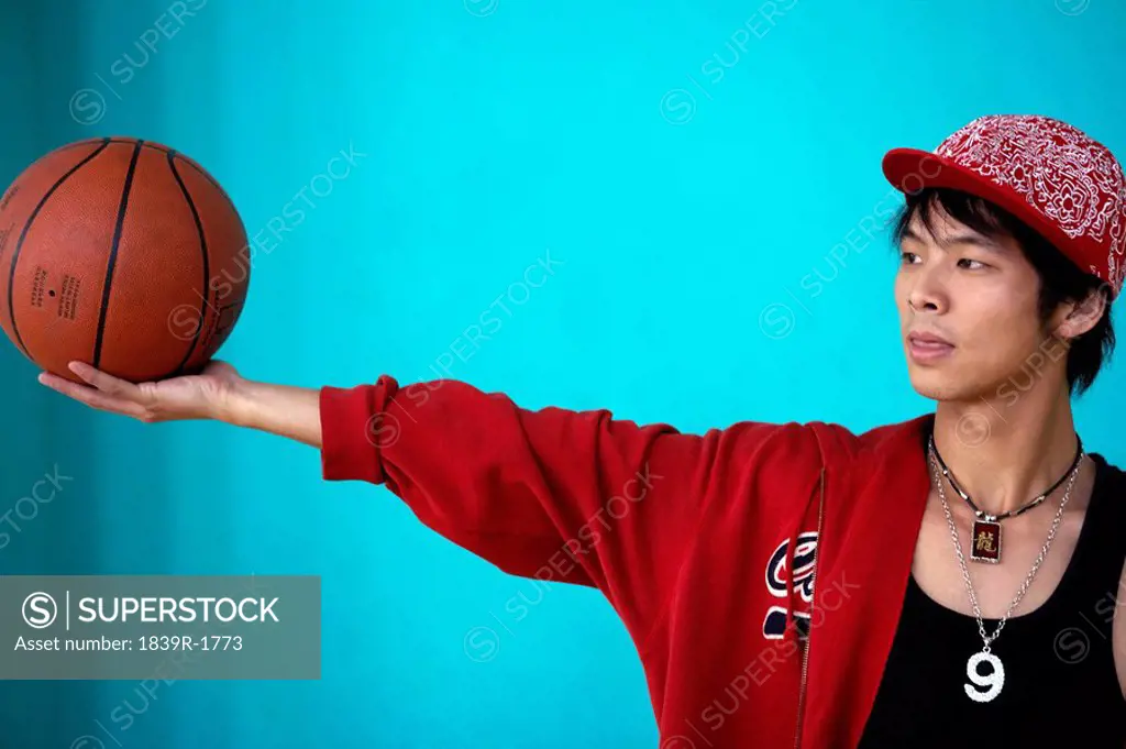 Young Man With His Arm Stretched Out Holding A Basketball